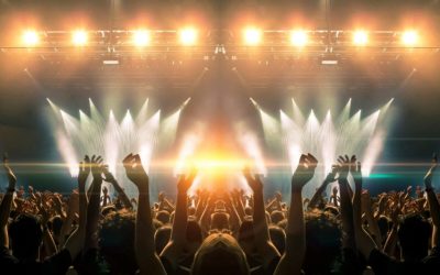 Photo of a concert hall with people silhouettes clapping in fron